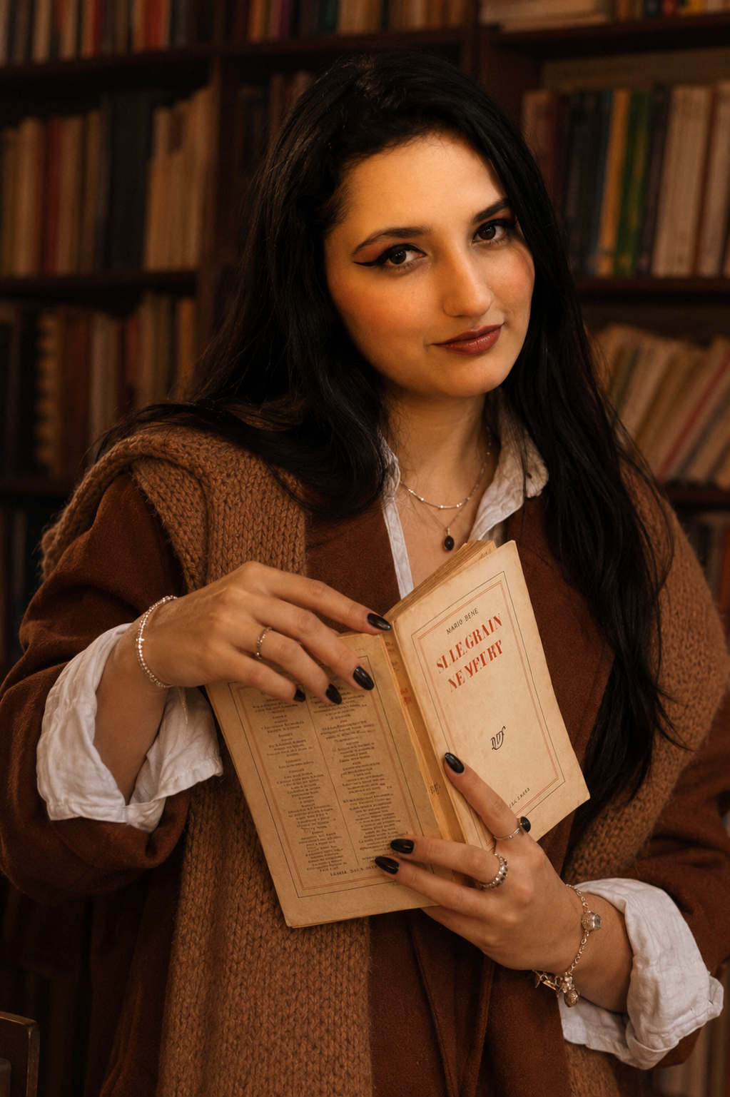 Tina Tobón sosteniendo un libro en una biblioteca